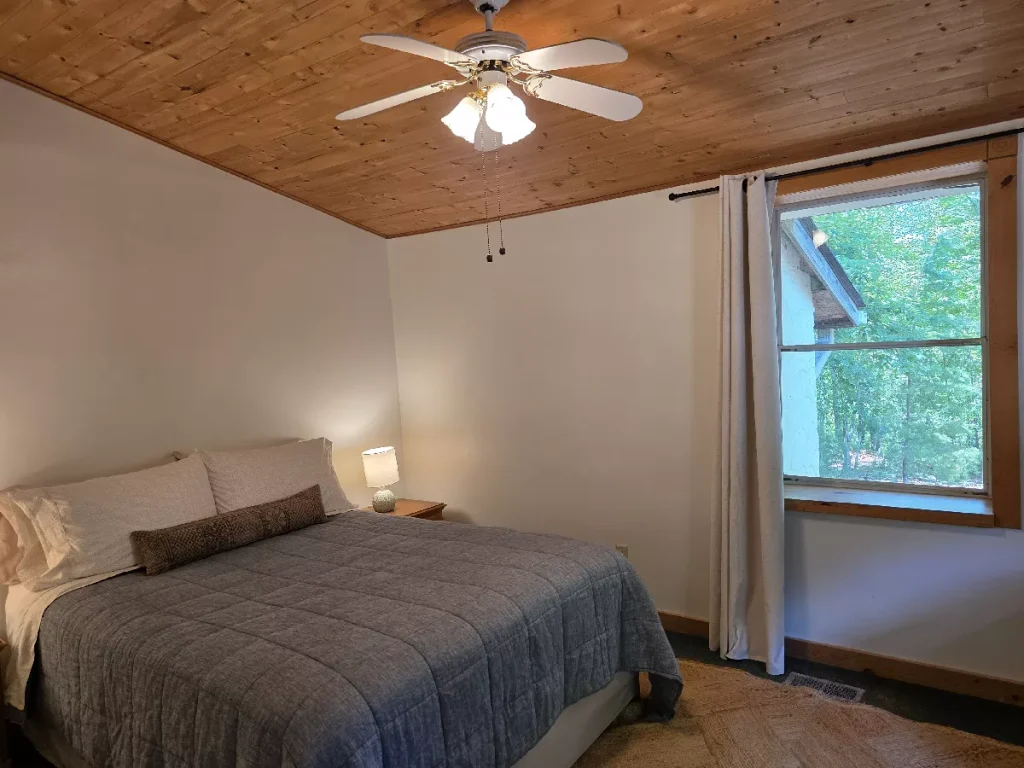 Queen bedroom with window view inside The Haven cottage at The Shaded Crest in Lake Lure, North Carolina