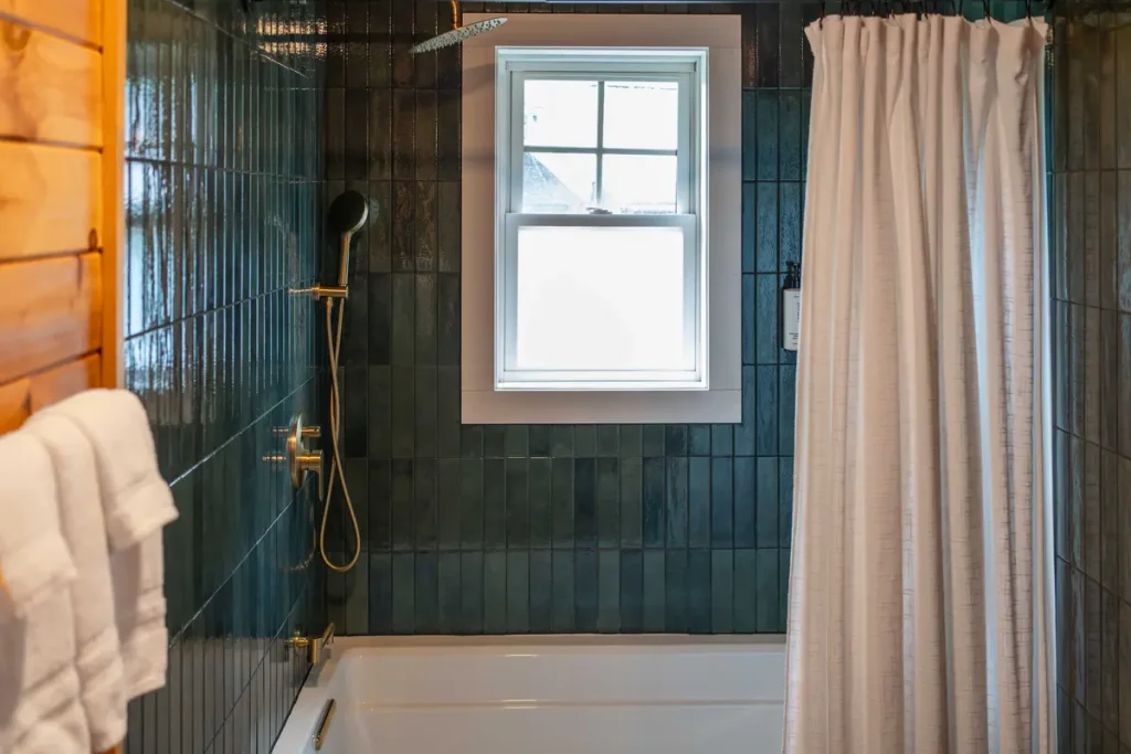 Shower tub combo with window inside The Perch cabin at The Shaded Crest in Lake Lure, North Carolina